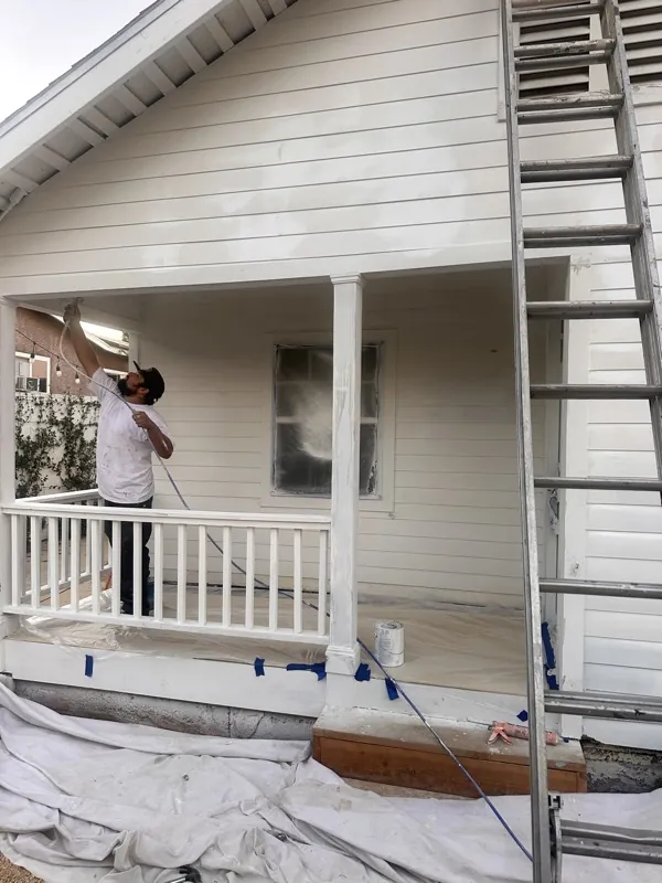 Spraying paint on the front porch