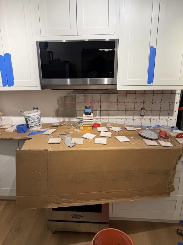 Setting backsplash tile in the kitchen