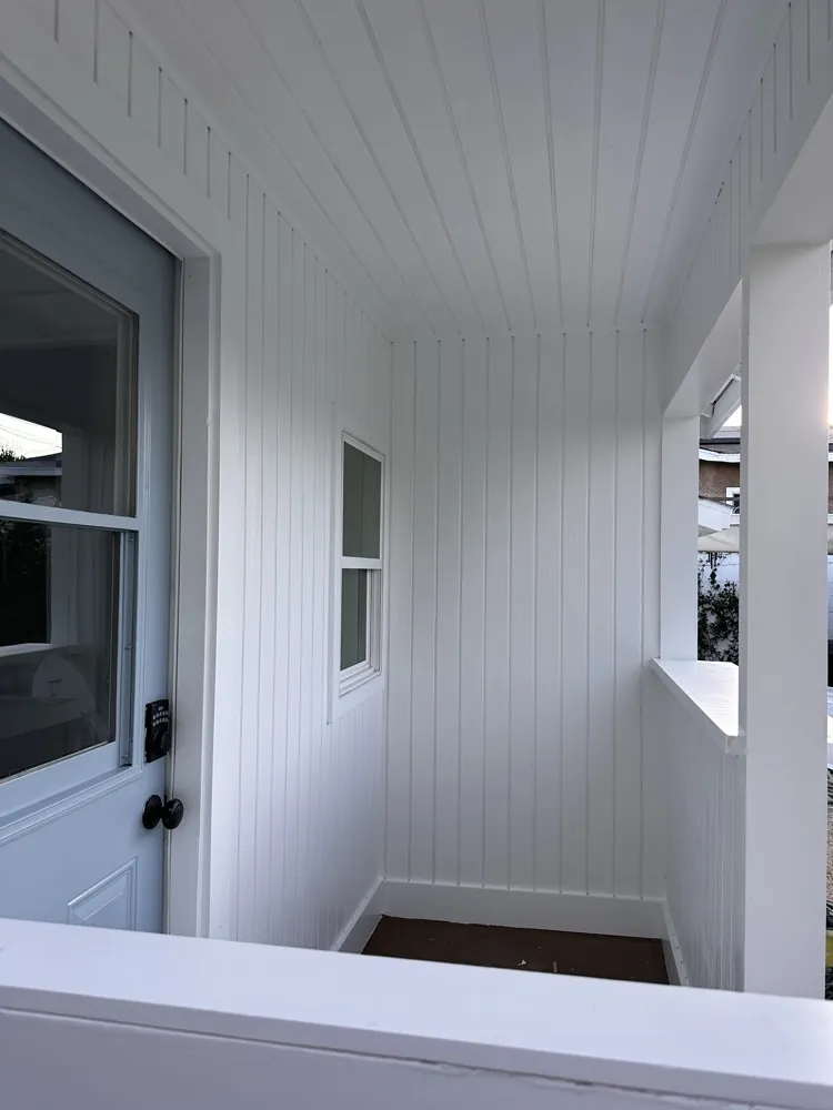 Rebuilt back porch with white paneling and finished floor