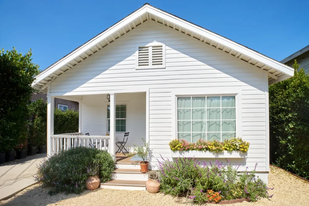 House after: freshly painted white exterior with new landscaping