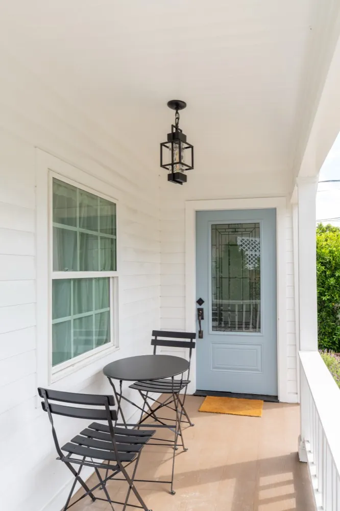 Finished front porch with light blue door and bistro seating