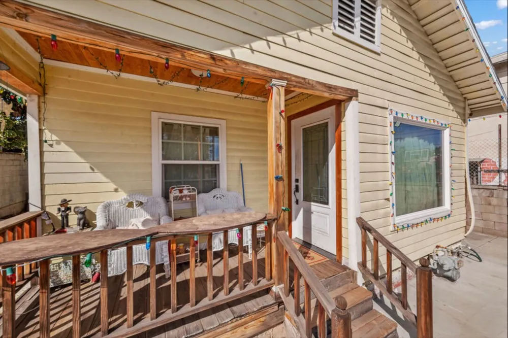 Front porch before: aged yellow siding and worn wood railings