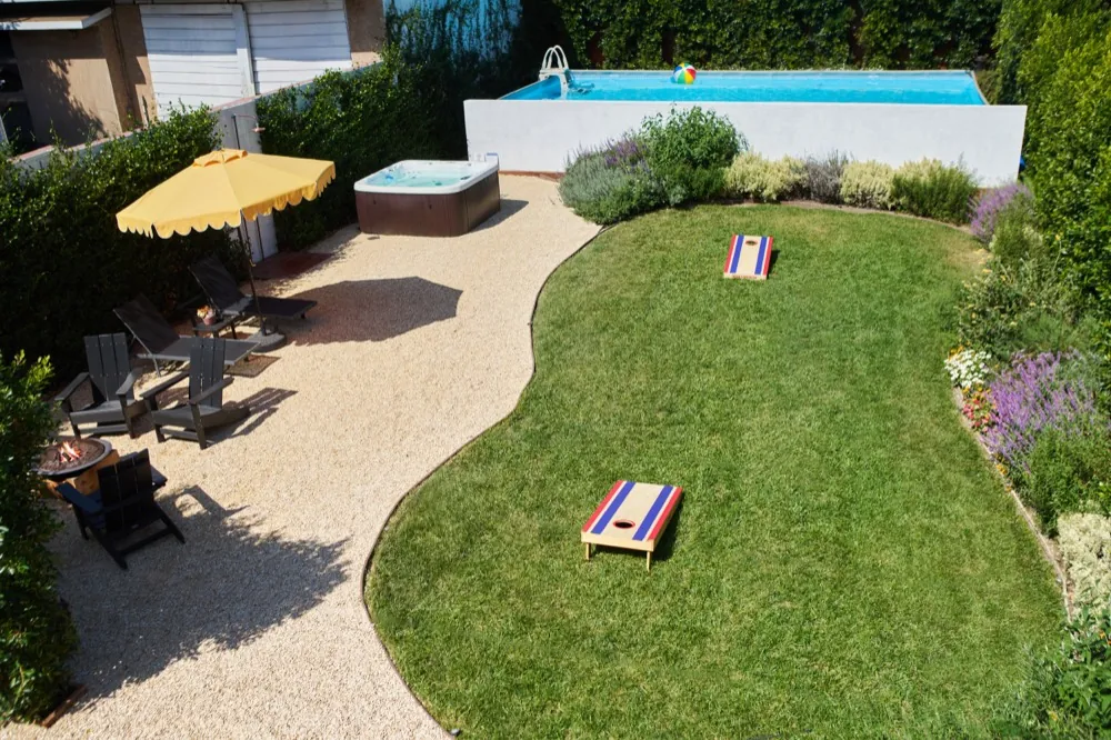 Backyard after: finished yard with pool, spa, lawn, and gravel patio