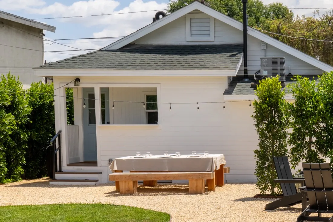 Back of the house with string lights and outdoor dining table