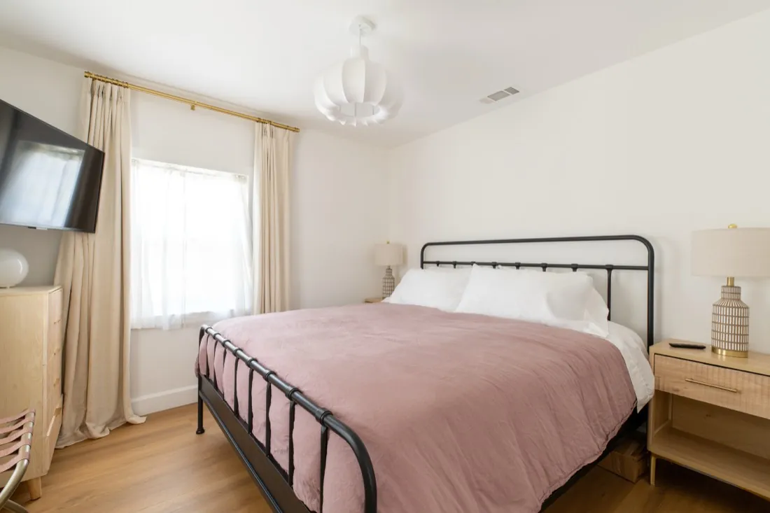 Bedroom with pink bedding and new lighting