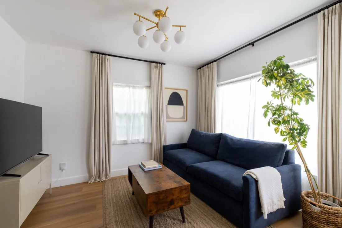 Bright living room with navy sofa and new flooring